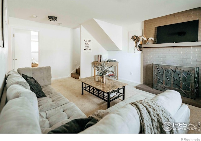 carpeted living area featuring stairway, baseboards, and a brick fireplace