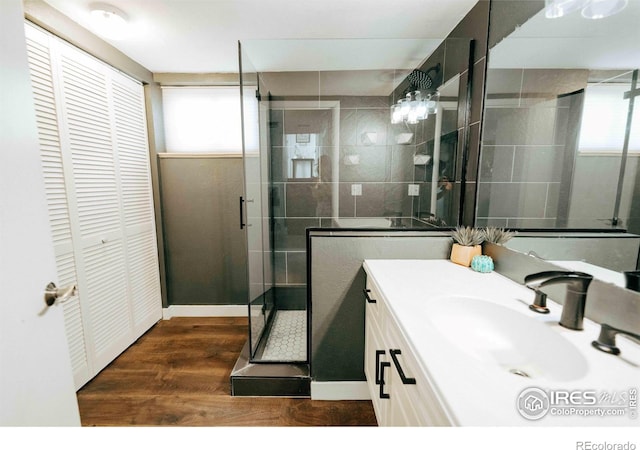 bathroom with vanity, a shower stall, wood finished floors, and a closet