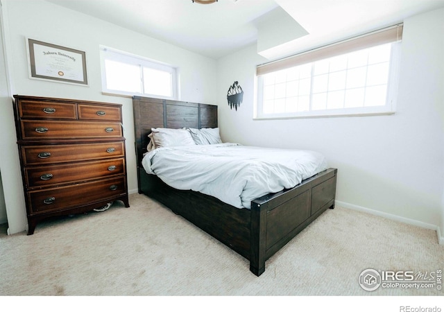 bedroom with baseboards and light colored carpet