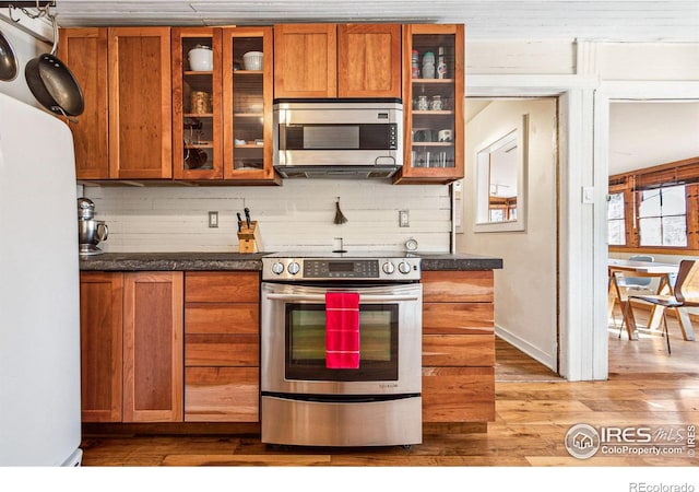 kitchen with tasteful backsplash, brown cabinets, and stainless steel appliances