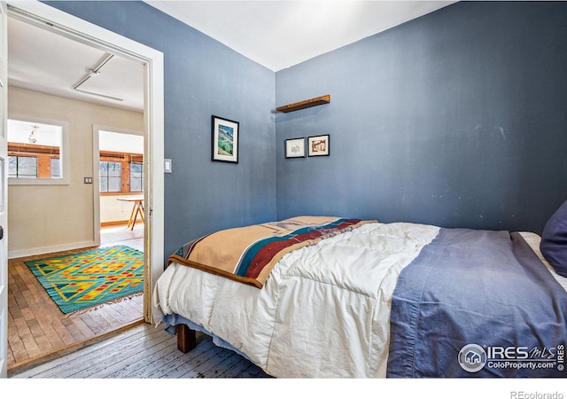 bedroom with hardwood / wood-style floors and baseboards