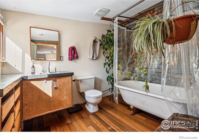 bathroom with visible vents, toilet, vanity, and wood finished floors