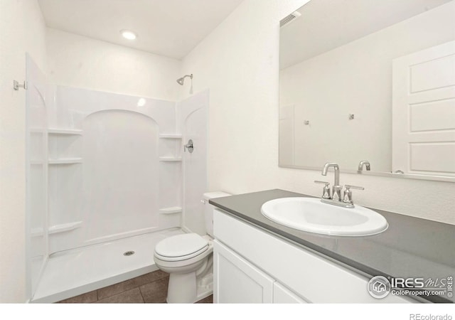 bathroom featuring visible vents, toilet, tile patterned flooring, a shower, and vanity