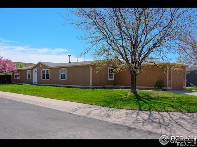 view of front facade featuring a front lawn, a garage, and driveway