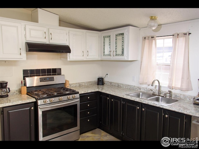 kitchen featuring under cabinet range hood, dark cabinetry, stainless steel gas stove, white cabinets, and a sink