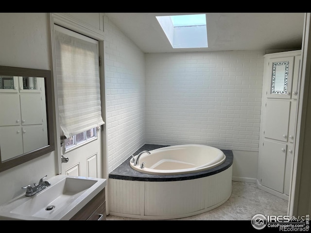 full bath featuring a garden tub, a skylight, and vanity