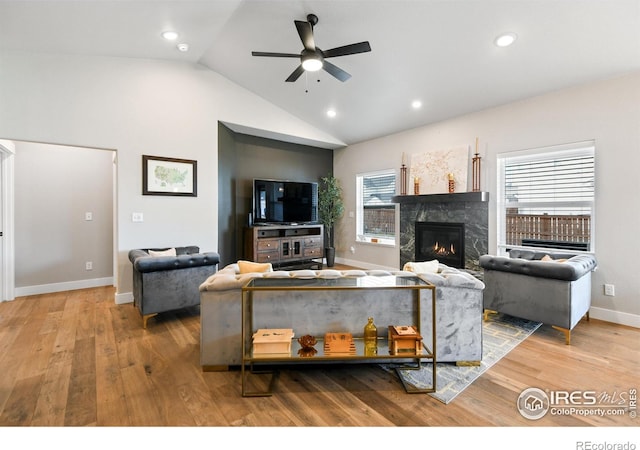 living area with a high end fireplace, ceiling fan, lofted ceiling, recessed lighting, and wood finished floors