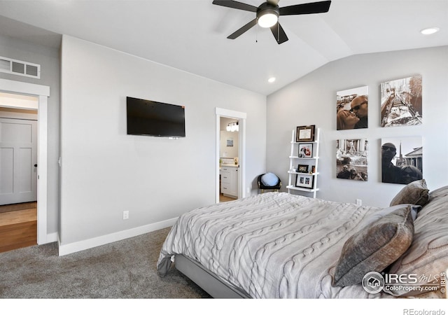 carpeted bedroom with visible vents, baseboards, vaulted ceiling, ensuite bath, and a ceiling fan