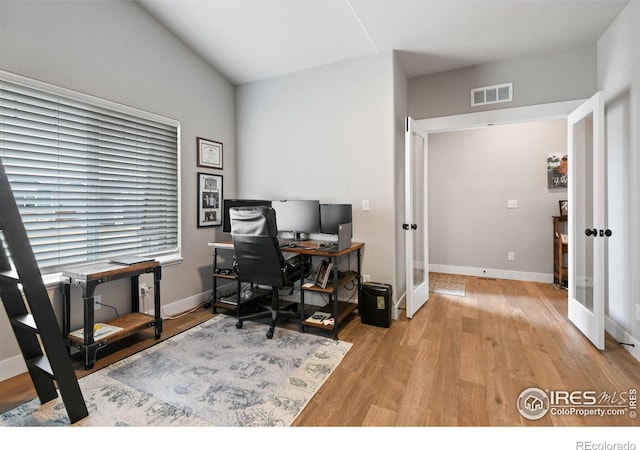 home office with visible vents, french doors, light wood-type flooring, and baseboards