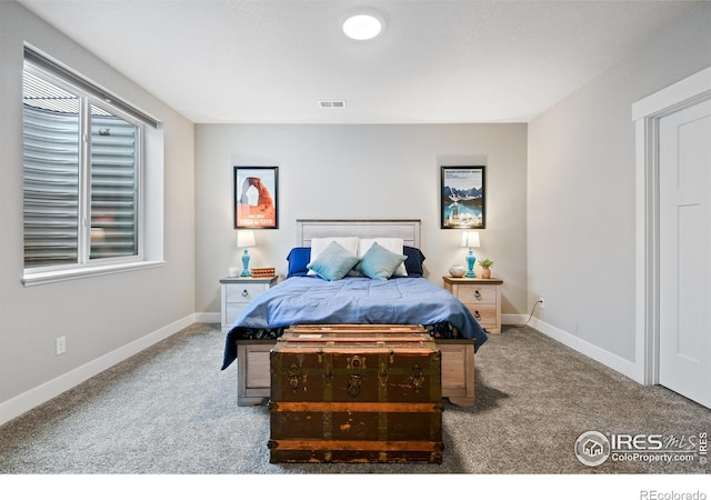 carpeted bedroom featuring baseboards and visible vents