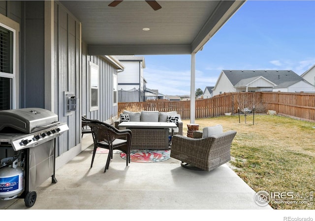 view of patio with grilling area, an outdoor hangout area, a fenced backyard, and a ceiling fan