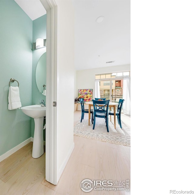 dining area featuring visible vents, baseboards, and wood finished floors