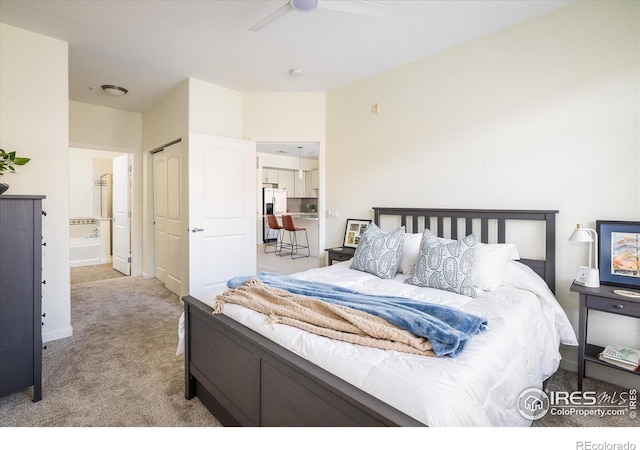 bedroom with a ceiling fan, stainless steel refrigerator with ice dispenser, ensuite bath, carpet floors, and baseboards