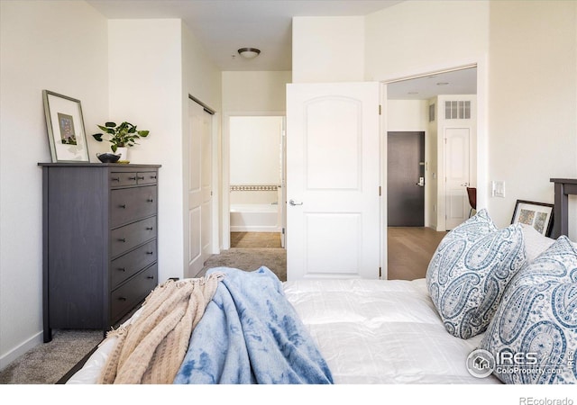 bedroom with visible vents, ensuite bath, and baseboards