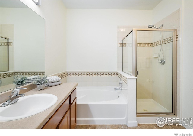 bathroom featuring vanity, a bath, a shower stall, and tile patterned flooring