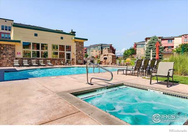 pool with a patio and a fireplace