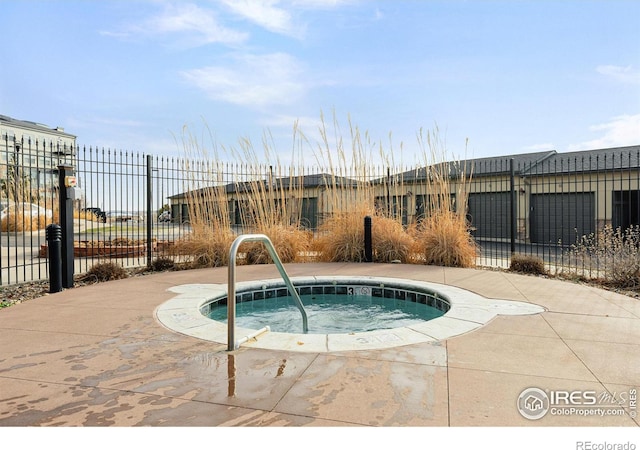 view of pool featuring fence and a hot tub