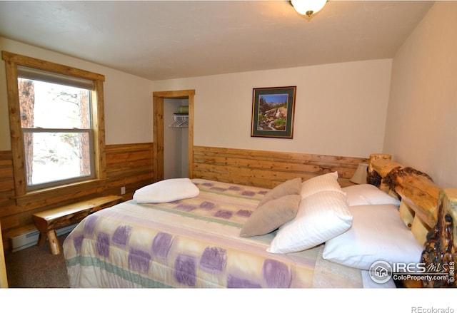 carpeted bedroom with a wainscoted wall and wood walls