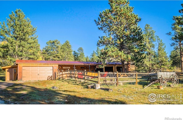 view of front facade featuring an outbuilding, an attached garage, driveway, and an exterior structure