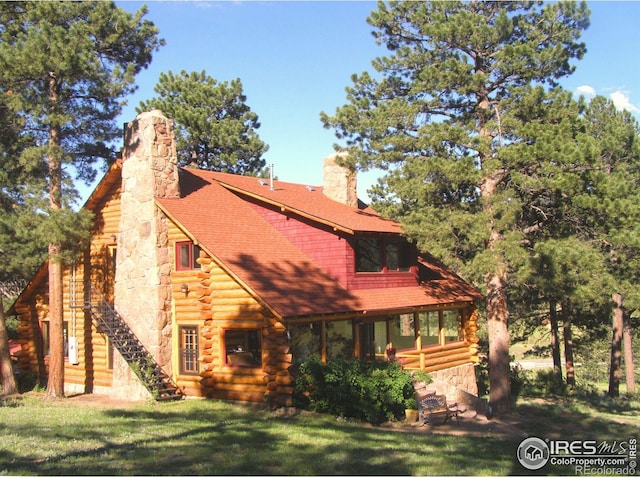 3501 Devils Gulch Rd, Estes Park, CO 80517 - view of front of property featuring log siding, a chimney, a front lawn, and stairs