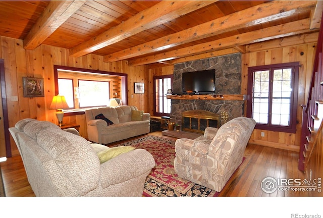 3501 Devils Gulch Rd, Estes Park, CO 80517 - living area featuring a wooden ceiling with exposed beams, wood walls, hardwood / wood-style floors, and a fireplace