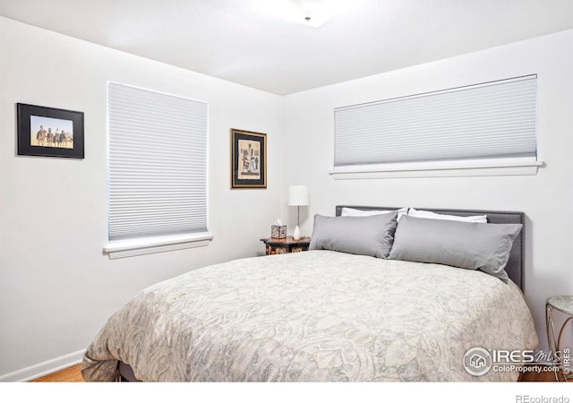 bedroom featuring wood finished floors and baseboards