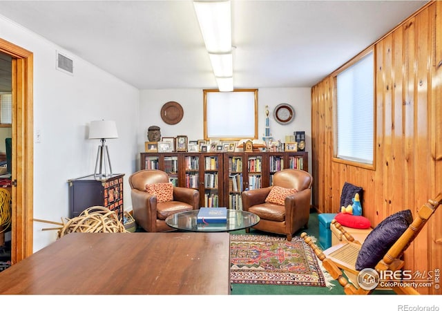 living area with visible vents and wooden walls