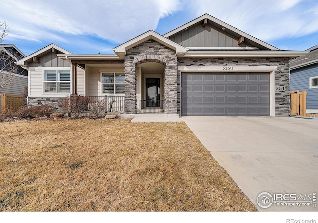 craftsman house with concrete driveway, an attached garage, board and batten siding, and stone siding