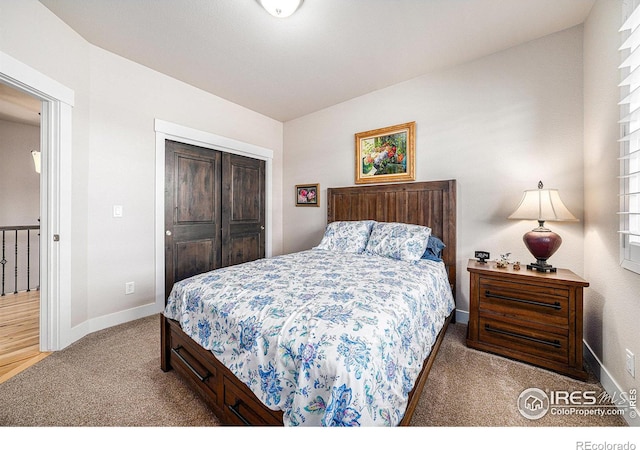 carpeted bedroom with a closet and baseboards