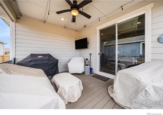 wooden deck with grilling area and ceiling fan