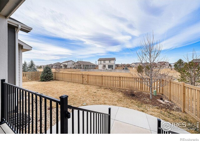 view of yard with a patio, a fenced backyard, and a residential view