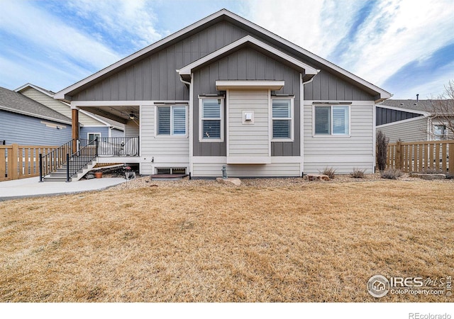 view of front of home with a front yard, fence, and board and batten siding