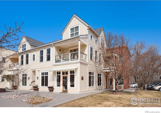 back of property featuring entry steps and a balcony