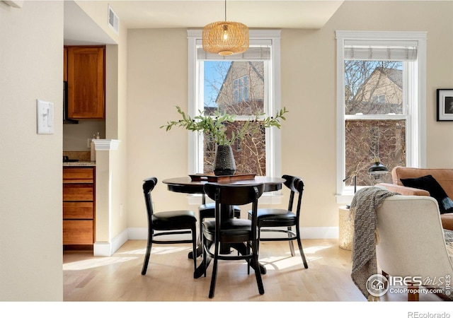 dining room featuring visible vents, baseboards, and light wood-style flooring
