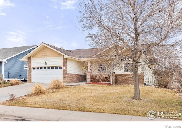 view of front of home featuring a front yard, roof with shingles, concrete driveway, a garage, and brick siding