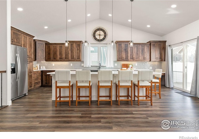 kitchen featuring decorative light fixtures, light countertops, stainless steel refrigerator with ice dispenser, and dark wood-style flooring