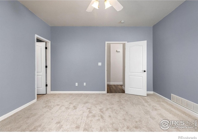 empty room with a ceiling fan, visible vents, carpet floors, and baseboards