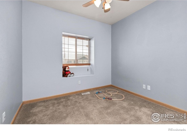 carpeted empty room with visible vents, a ceiling fan, and baseboards