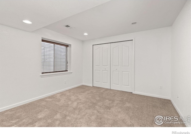 unfurnished bedroom featuring recessed lighting, visible vents, carpet floors, and baseboards