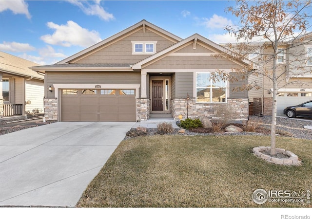 craftsman house featuring a garage, stone siding, a front lawn, and driveway