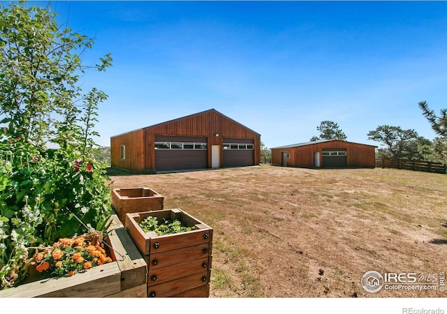 view of yard featuring an outbuilding, a detached garage, and an outdoor structure