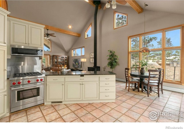 kitchen featuring dark countertops, cream cabinets, appliances with stainless steel finishes, and ceiling fan