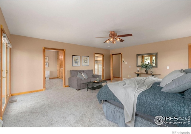 carpeted bedroom featuring connected bathroom, baseboards, and ceiling fan