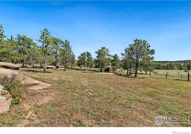 view of yard with a rural view and fence