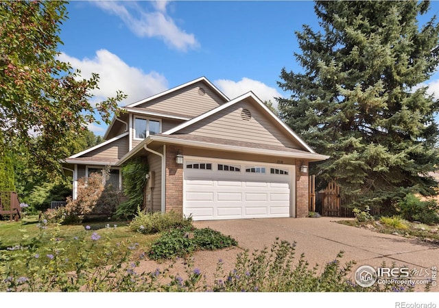 view of front facade featuring brick siding, an attached garage, driveway, and fence