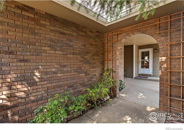 view of exterior entry with brick siding