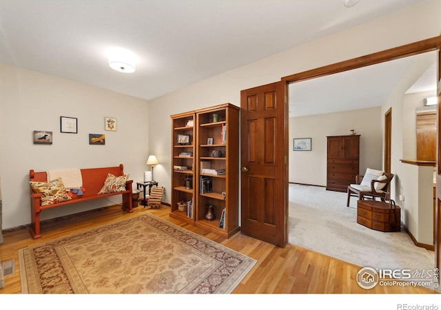 sitting room featuring baseboards and light wood-type flooring