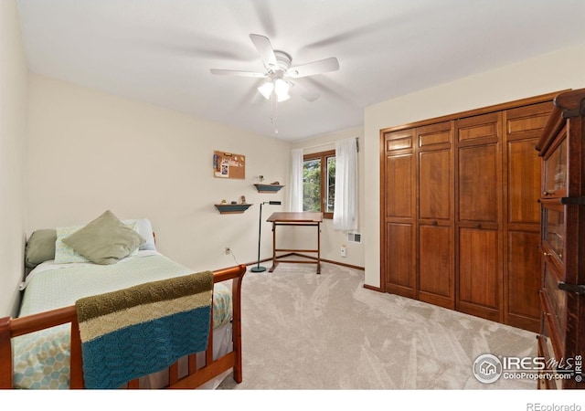 bedroom featuring light colored carpet, a ceiling fan, and baseboards