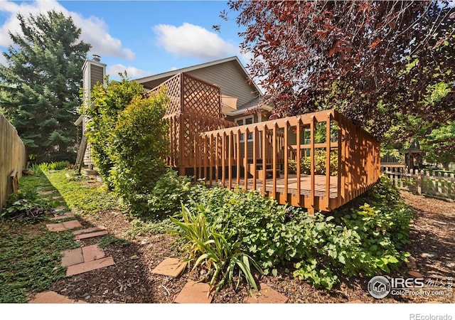 view of property exterior with fence and a wooden deck