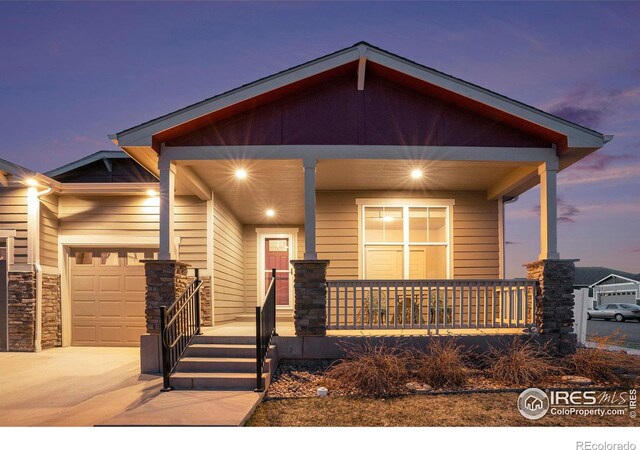 view of front of property featuring a garage, covered porch, and driveway